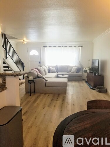 A kitchen with a bar stool and a trash bin.