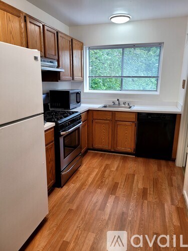 A kitchen with wooden floors and a white refrigerator.