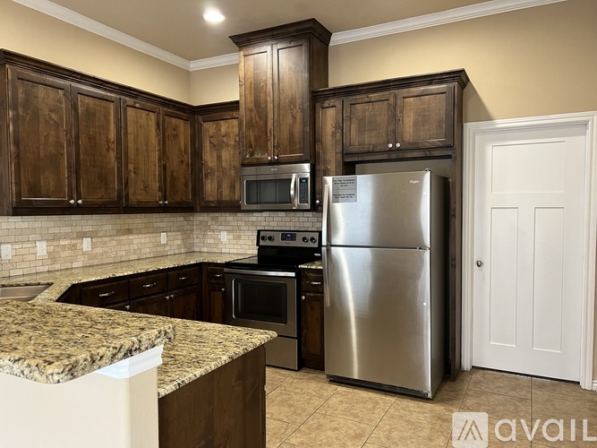 A kitchen with a granite countertop and stainless steel appliances.