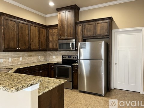 A kitchen with a granite countertop and stainless steel appliances.