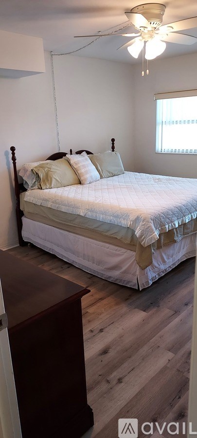 A bedroom with a bed and a wooden dresser.