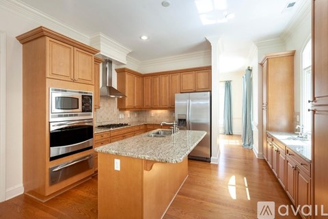 A kitchen with wooden cabinets and a granite countertop.
