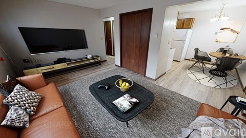 A living room with a brown leather couch and a black coffee table.