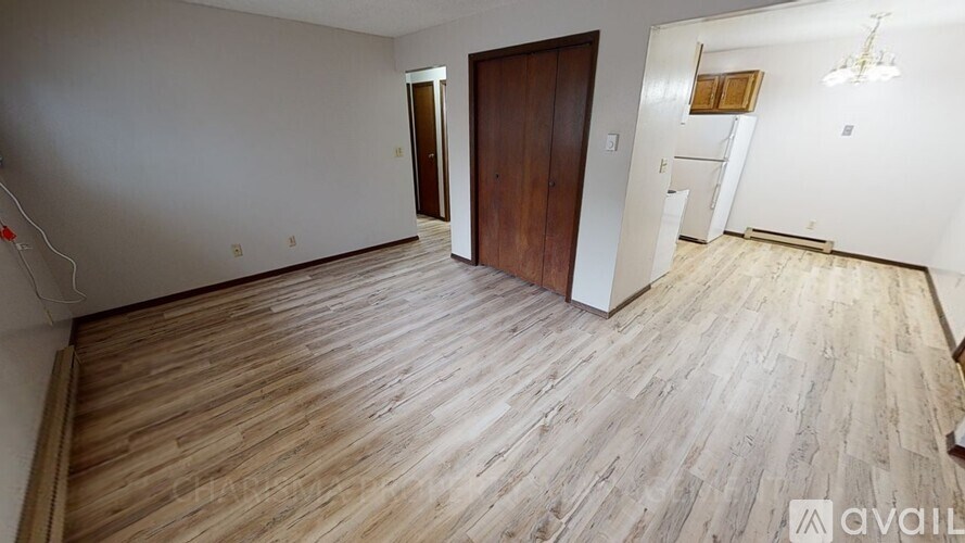A room with wooden flooring and a brown door.