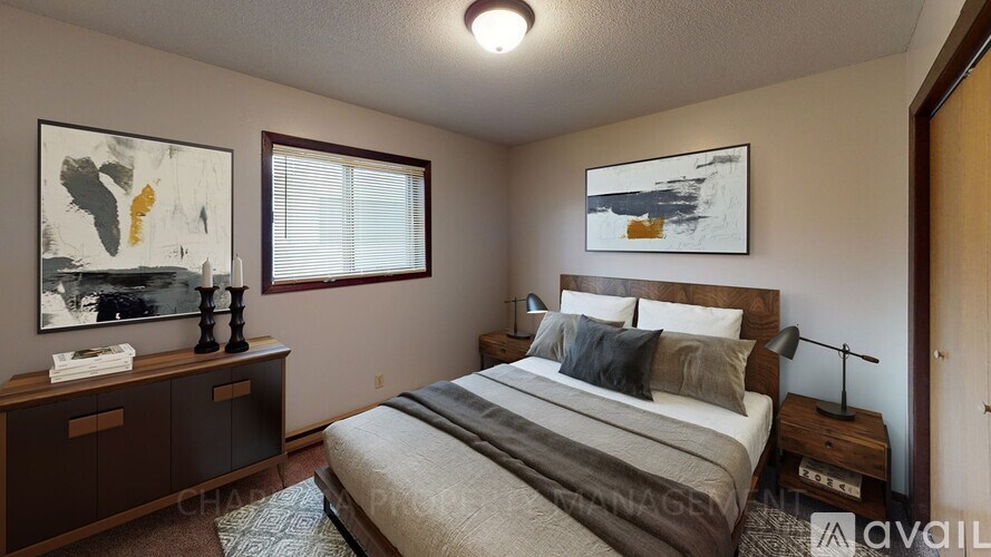 A bedroom with a large bed and two framed pictures on the wall.