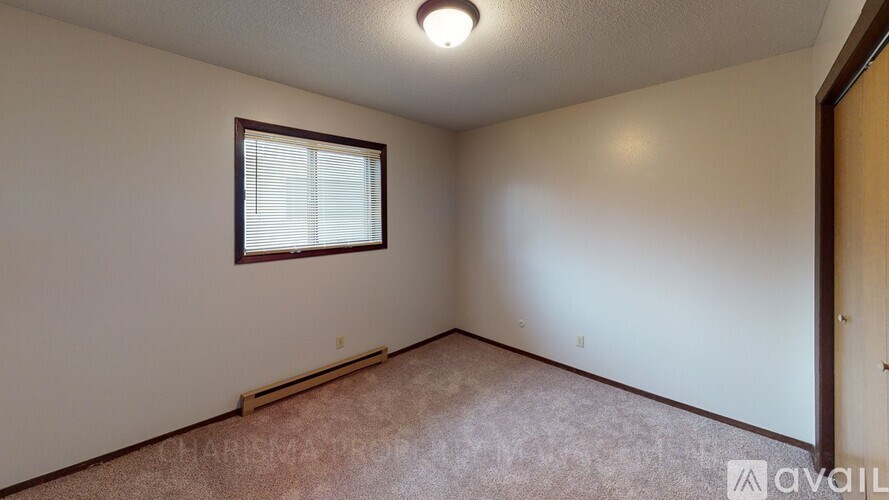 A room with a window and carpeted floor.