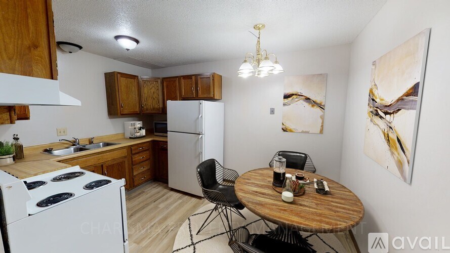 A kitchen with a white stove and a wooden table with two chairs.