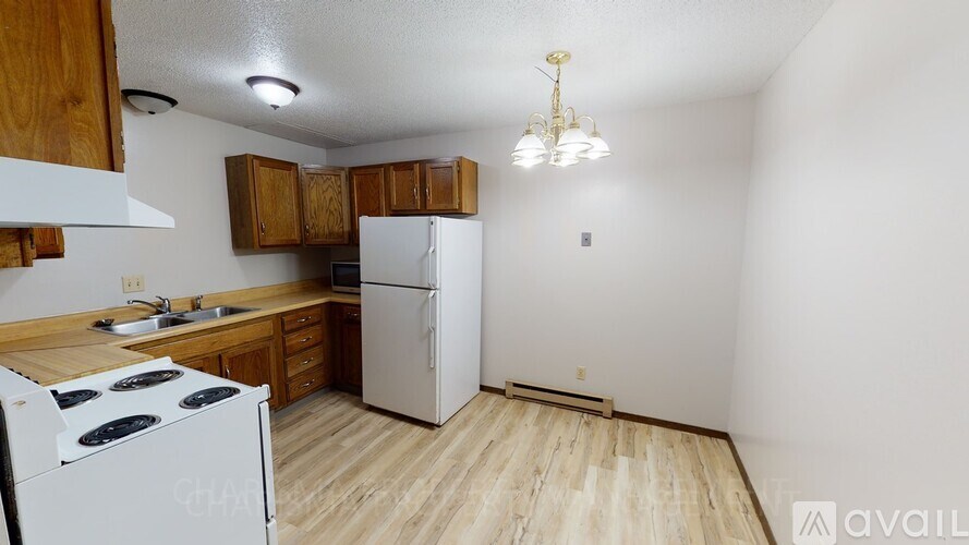 A kitchen with a white stove top oven and white refrigerator.