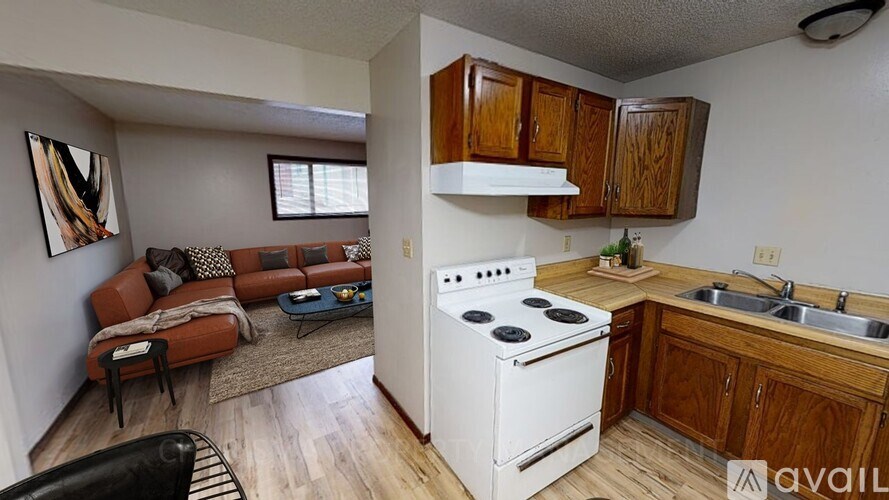 A kitchen with a white stove top oven and wooden cabinets.