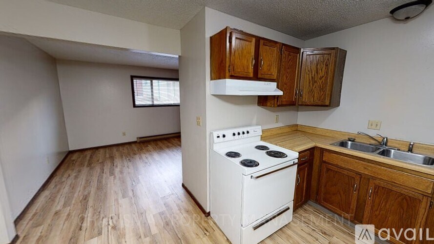 A kitchen with a white stove and wooden cabinets.