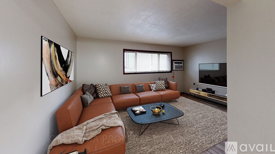 A living room with a brown leather couch and a painting on the wall.