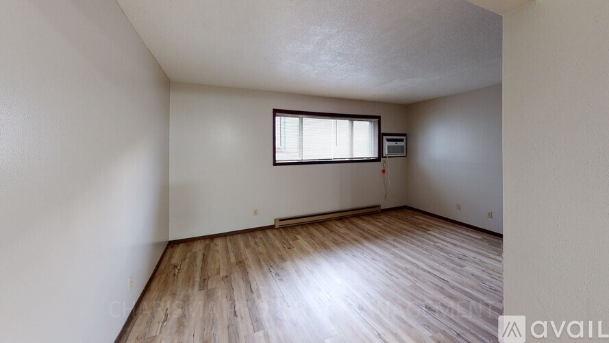 A room with wooden flooring and a window.