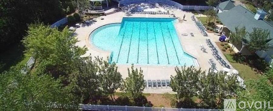 A large outdoor swimming pool surrounded by trees.