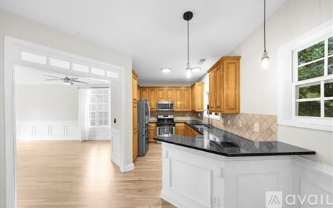 A kitchen with wooden cabinets and a black countertop.