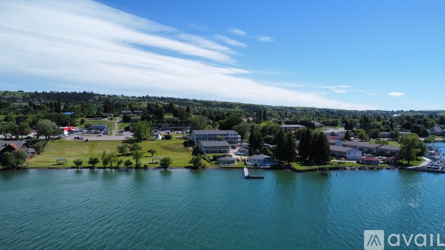 A bird's eye view of a lake surrounded by houses and trees.