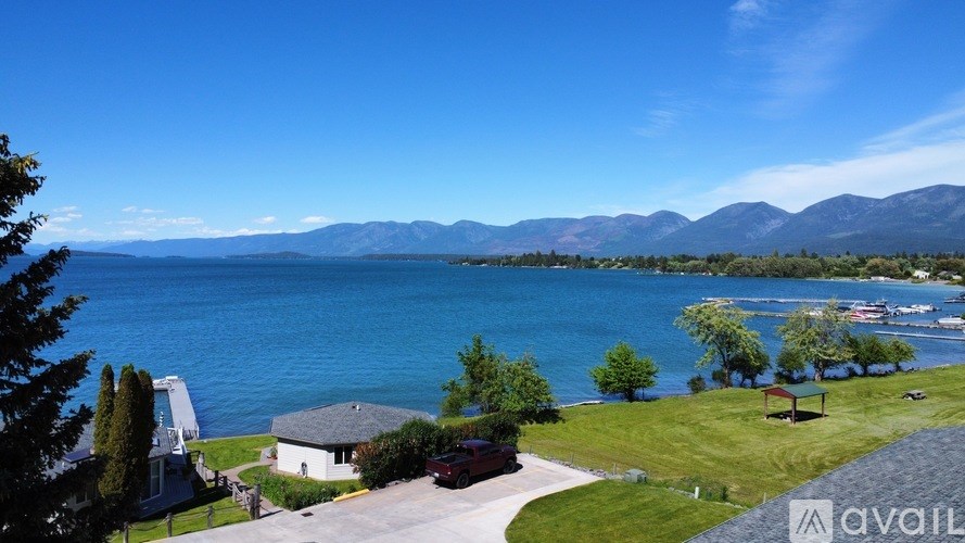 A house with a driveway and a mountain range in the background.