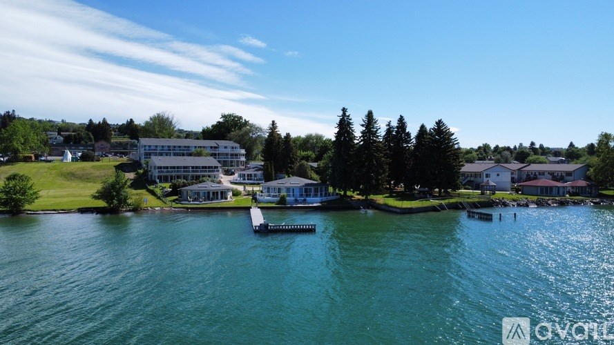 A body of water with a dock and a house in the background.