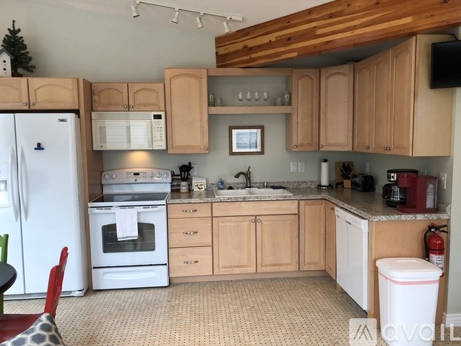 A kitchen with wooden cabinets and a white fridge.