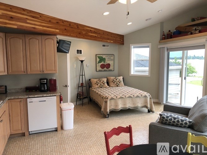 A bedroom with a bed, a chair, and a window.