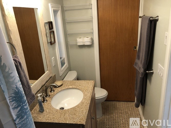 A bathroom with a toilet, sink, and a door.