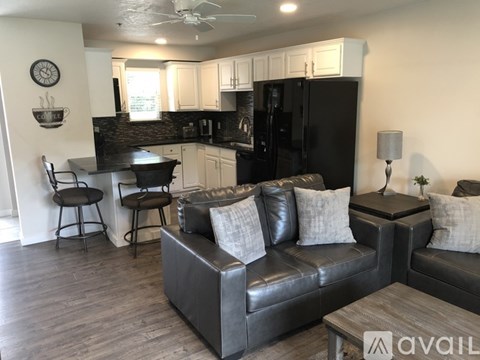 A living room with a black couch and a wooden coffee table.