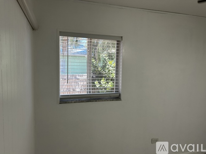 A window with a view of a building and trees outside.
