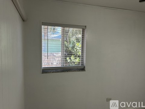 A window with a view of a building and trees outside.
