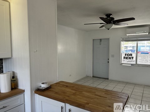 A room with a wooden table and a fan on the ceiling.