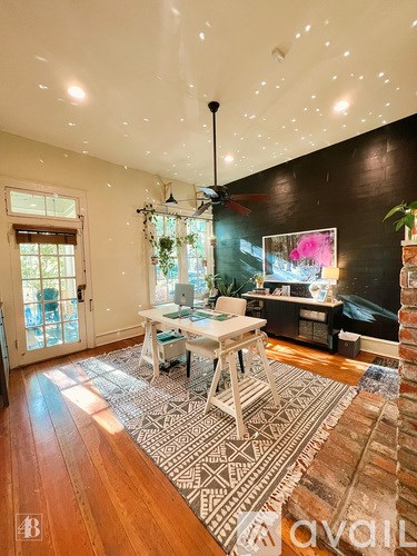 A living room with a white table and a rug with a geometric pattern.