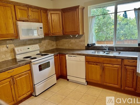 A kitchen with wooden cabinets and white appliances.