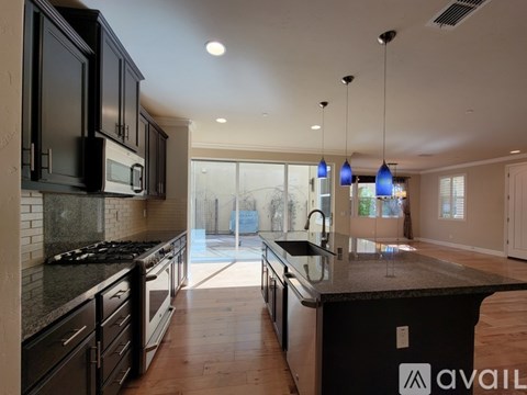 A modern kitchen with black cabinets and a large island.