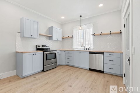 A kitchen with wooden floors and white walls.