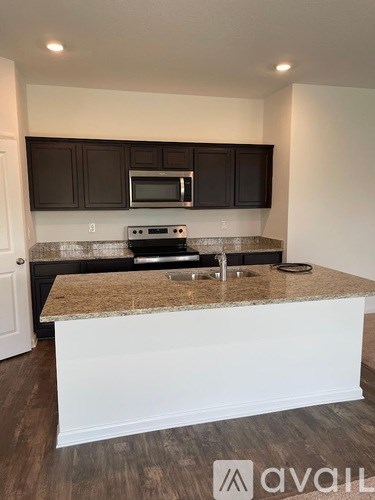 A kitchen with brown cabinets and a granite countertop.