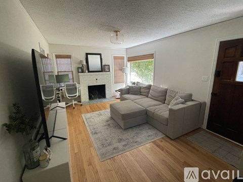 A living room with a grey couch and a television.