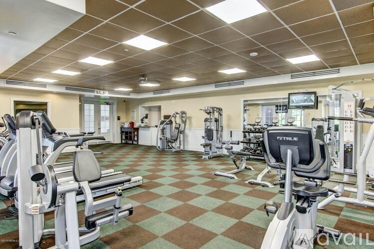 A gym with a variety of equipment including a treadmill, weights, and a television.