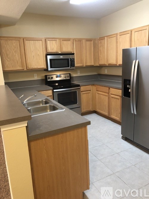 A kitchen with wooden cabinets and a stainless steel refrigerator.