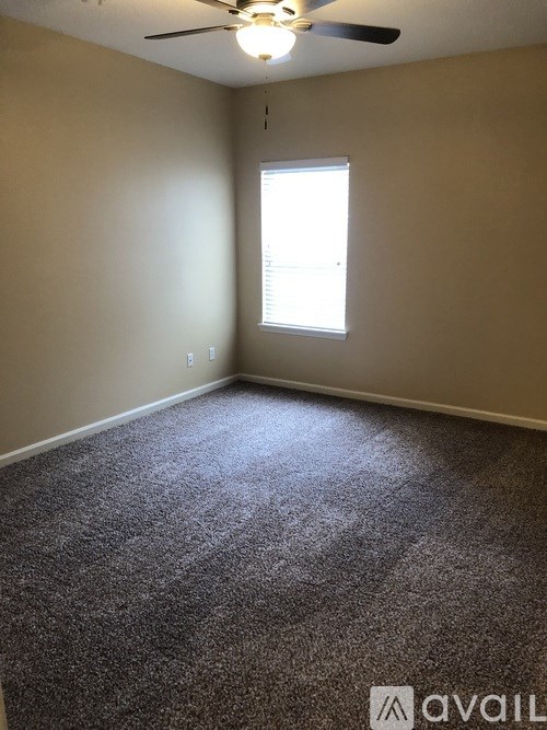 A room with a ceiling fan and a window.
