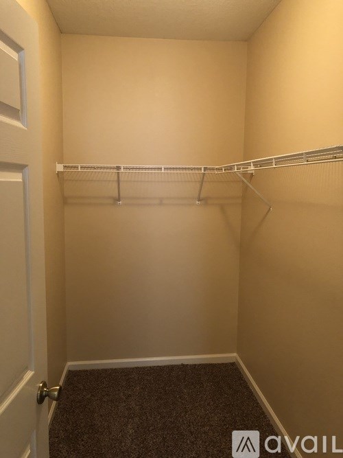 A small, empty room with a carpeted floor and a white door.