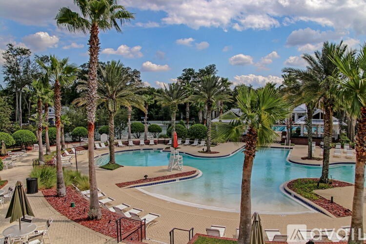 A pool surrounded by palm trees and red brick.