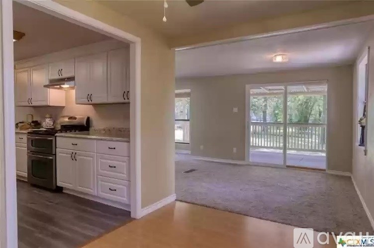 A kitchen with white cabinets and a dining table.