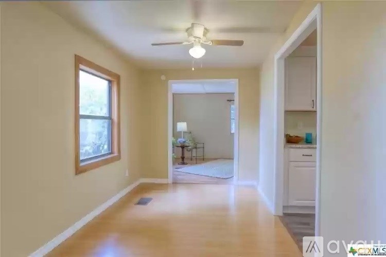 A room with a ceiling fan and a window.