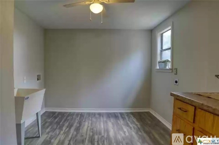 A room with a ceiling fan and a window.