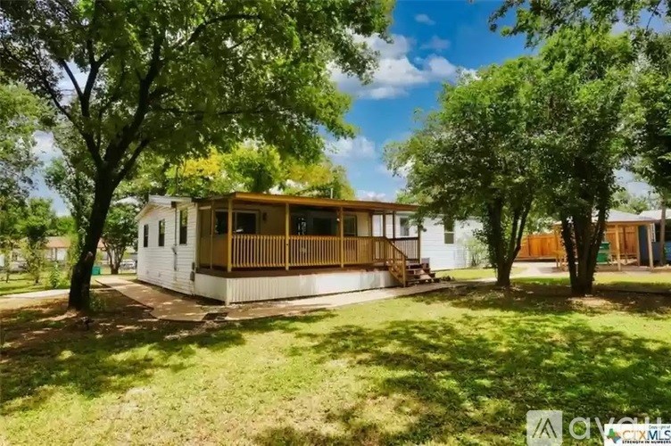 A house with a porch surrounded by trees.