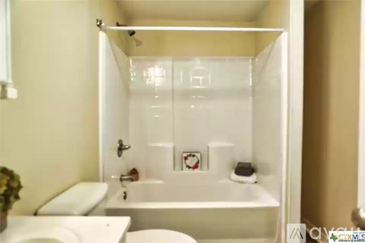 A white bathroom with a toilet, sink, and bathtub.