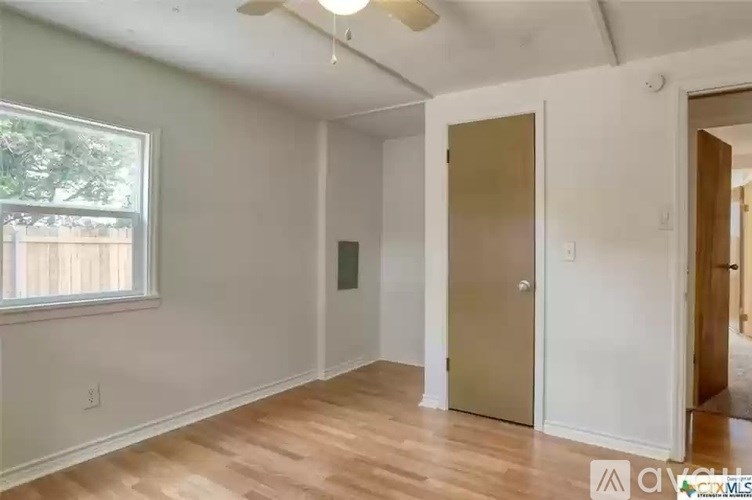 A room with a wooden floor and a window.