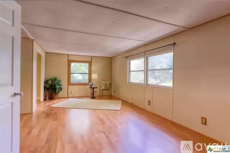 A room with wooden floors and a rug in the middle.