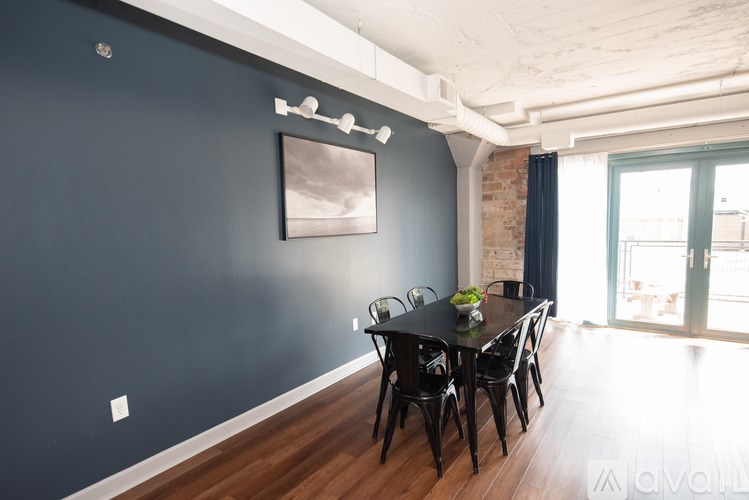 A dining room with a black table and chairs.