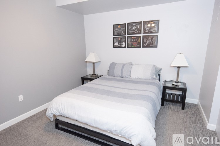 A bedroom with a large bed and two lamps.