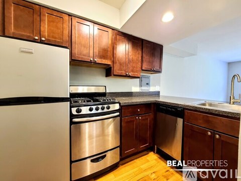 A kitchen with wooden cabinets and a white fridge.