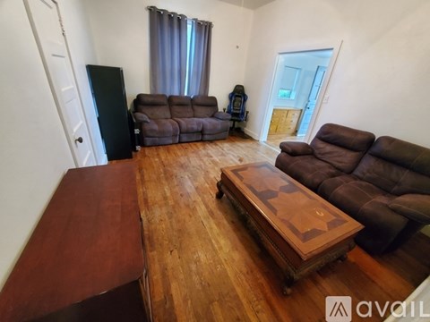 A living room with a brown coffee table and brown leather couches.